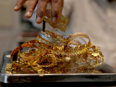 Gold gains on weaker dollar, easing inflation concerns